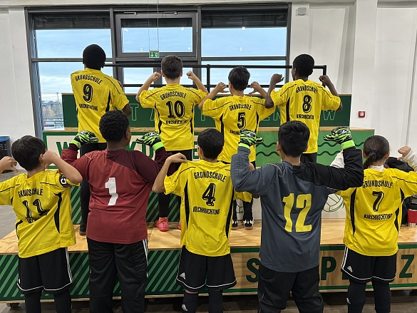 Eine Kinderfußballmannschaft von hinten fotografiert