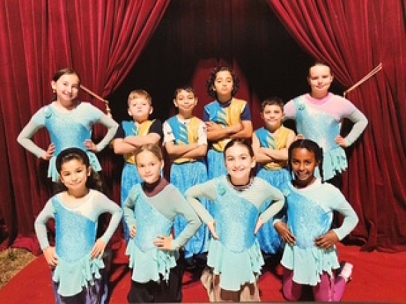 Viele Kinder stehen vor einem roten Vorhang