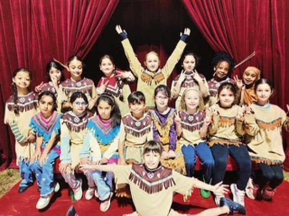 Viele Kinder stehen vor einem roten Vorhang