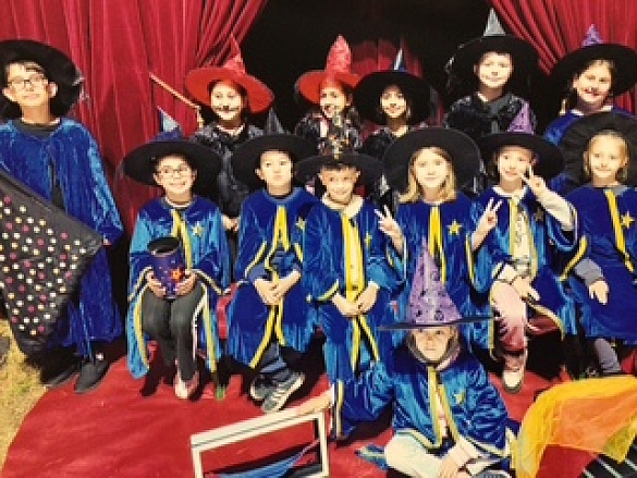 Viele Kinder stehen vor einem roten Vorhang