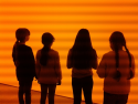 Kinder vorn einer orangen Wand